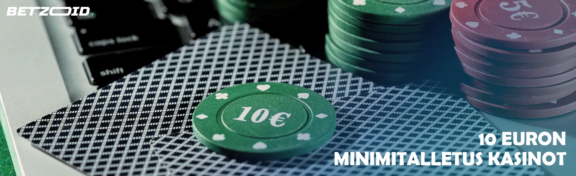 Kasinokortit ja pelimerkit ovat kannettavan tietokoneen näppäimistöllä.