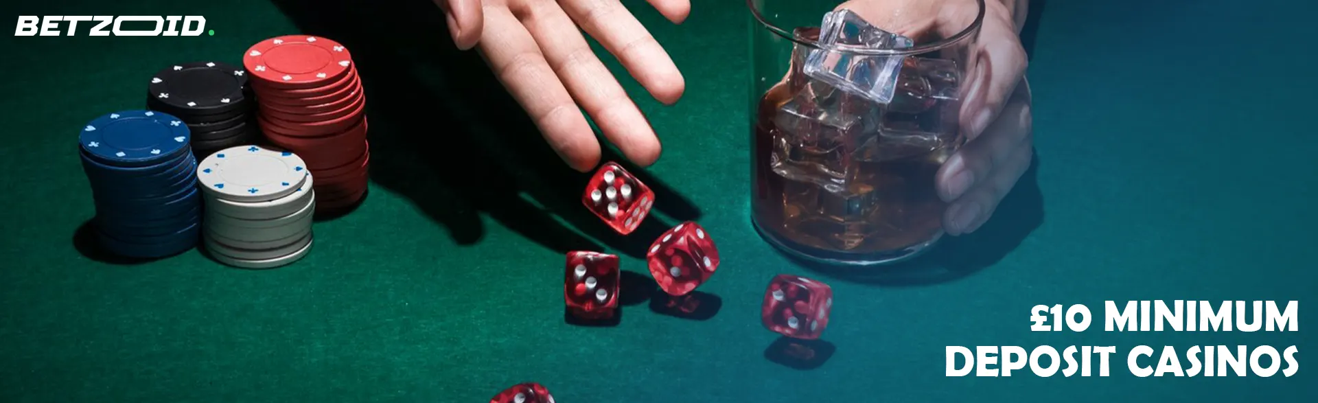 A player rolls dice next to casino chips and a drink in a glass.
