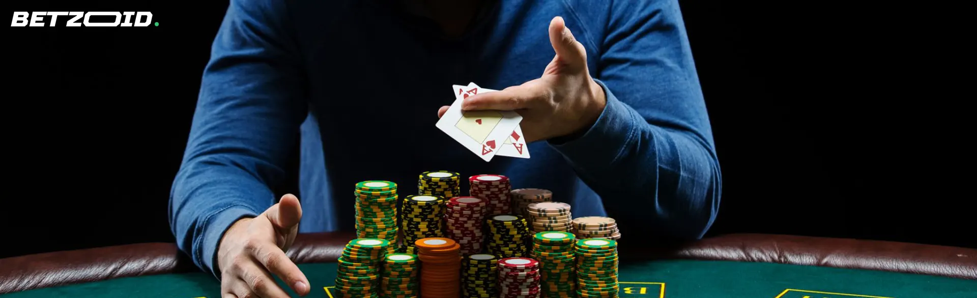 The player holds the cards above the casino chips.