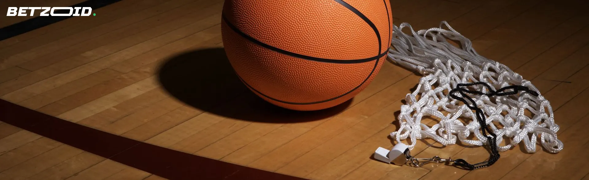 Un ballon de basket repose à côté du filet.