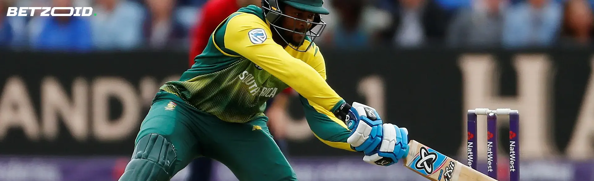 A cricketer hits the ball with a bat.
