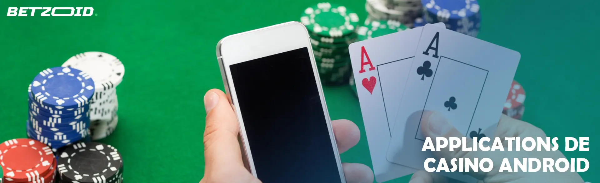 Le joueur tient les cartes et le téléphone à côté des jetons du casino.