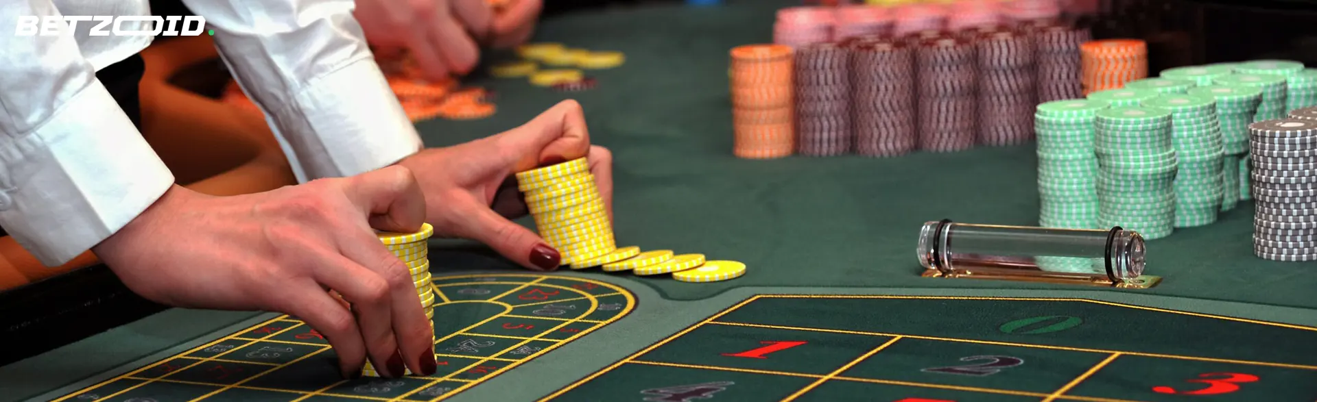 A player holds chips on the casino table.