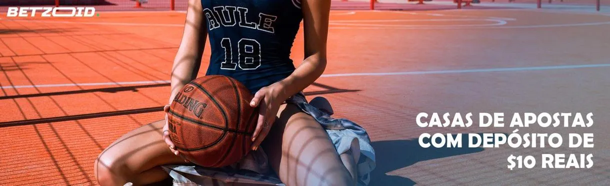 Um jogador de basquete está sentado na quadra com uma bola.