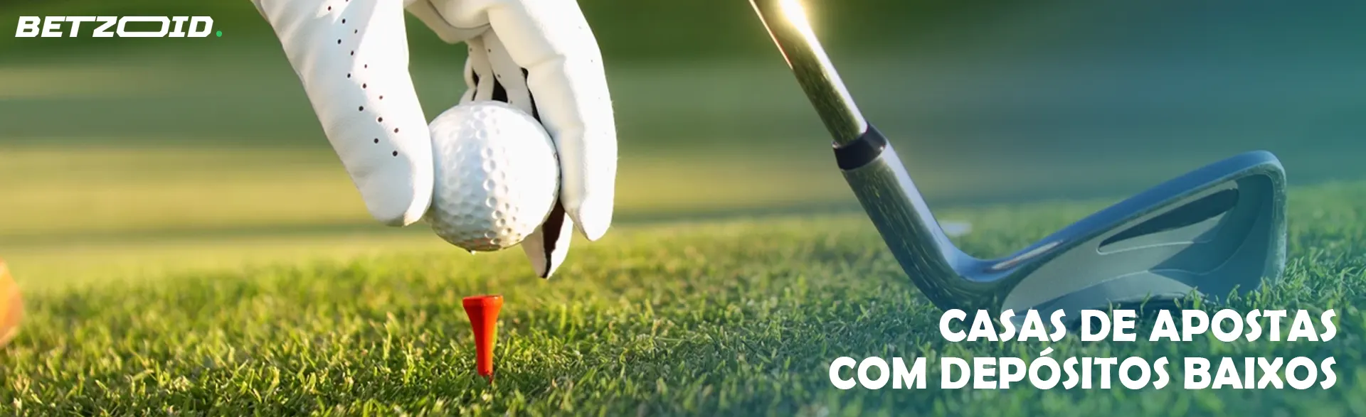 Um jogador de golfe se prepara para bater a bola no campo.