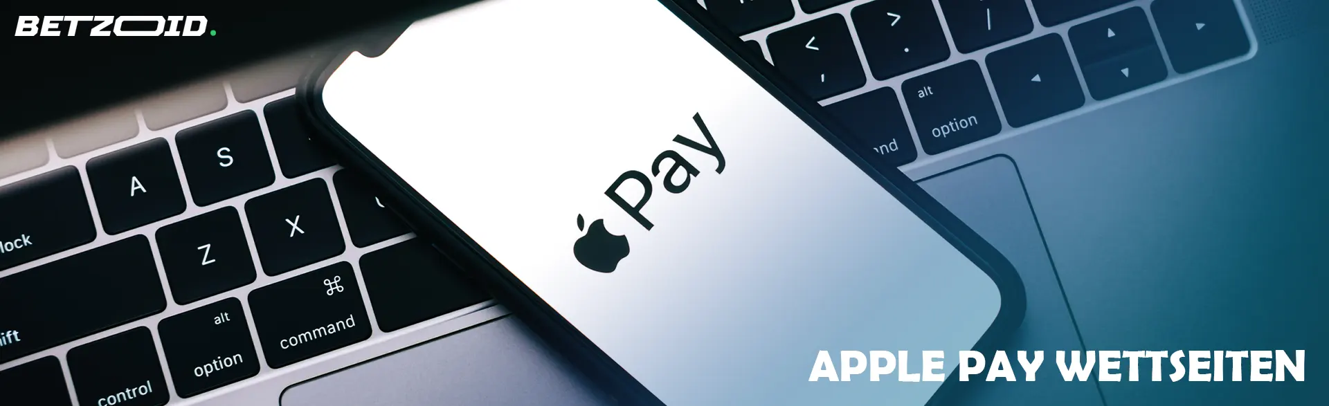 Auf der Tastatur liegt ein Smartphone mit dem Apple Pay-Logo.