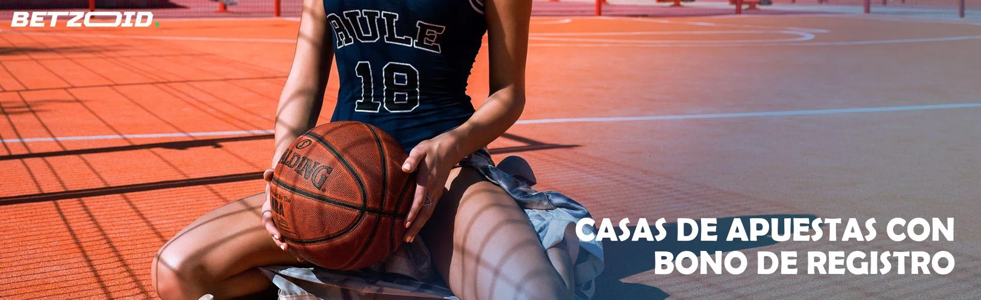 Niña sentada con una pelota de baloncesto.
