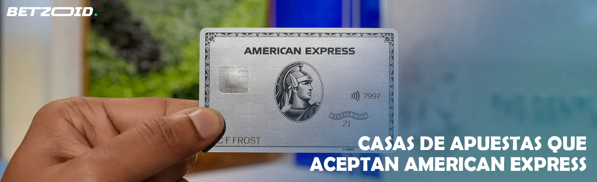Un hombre sostiene una tarjeta American Express en su mano.