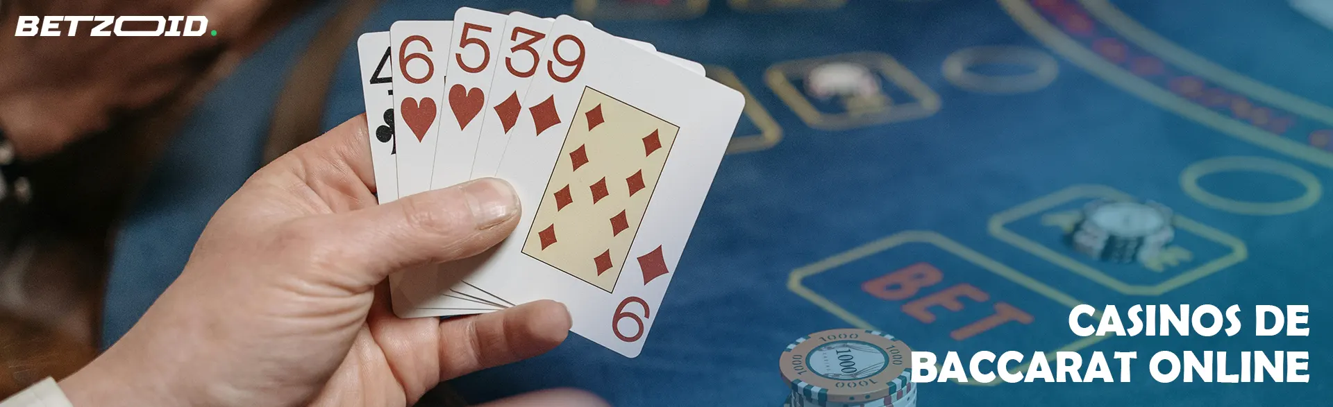 El jugador sostiene cartas en el fondo de la mesa del casino.