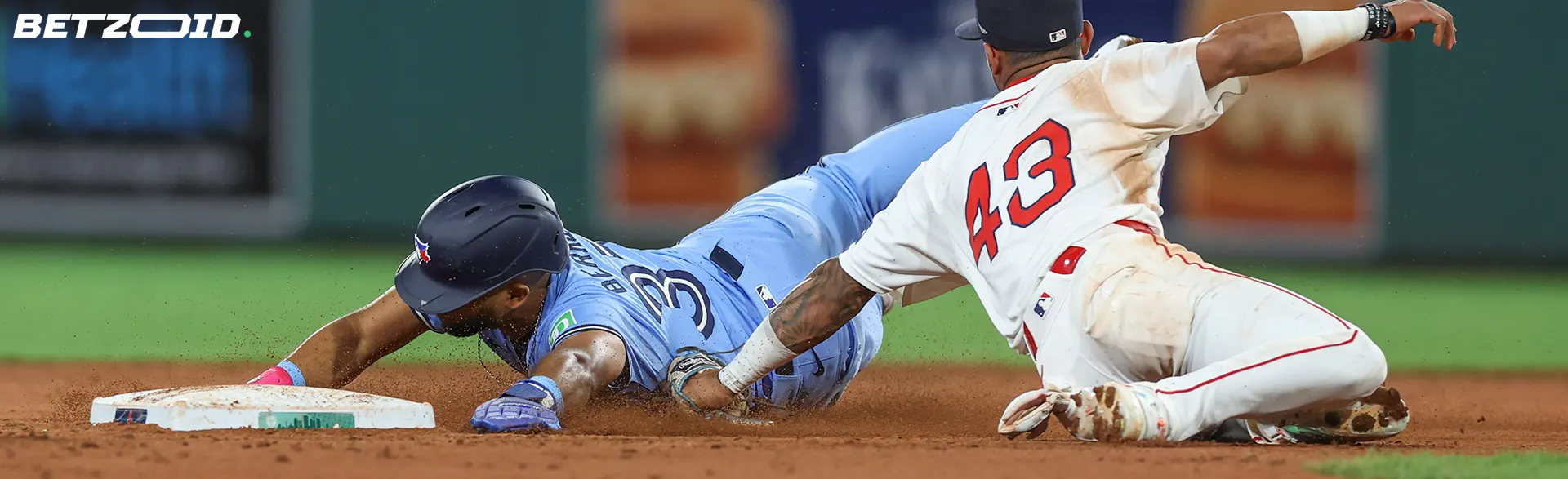 A baseball player in blue sliding to a base while a player in white attempts to tag, representing best betting sites in Newfoundland.