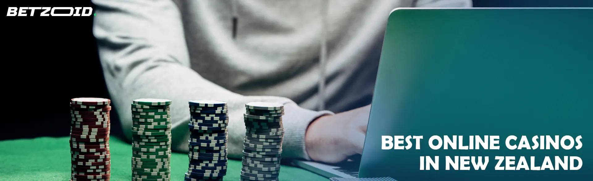 A gambler at a laptop next to casino chips.