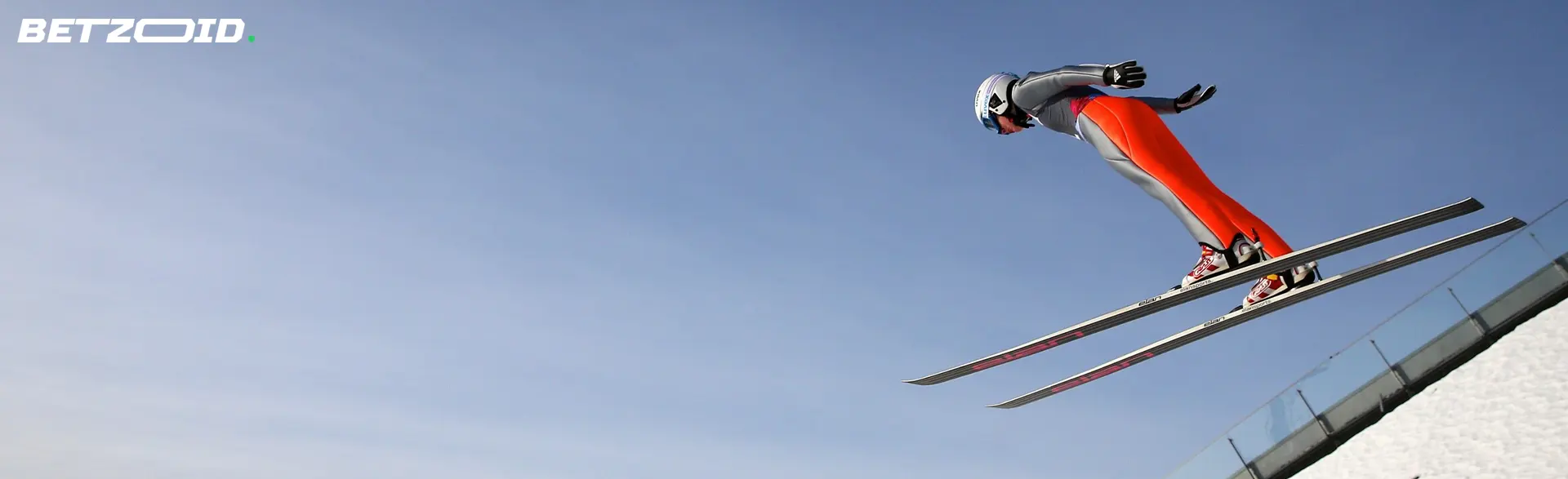 Ein Skifahrer springt von einer Schanze.