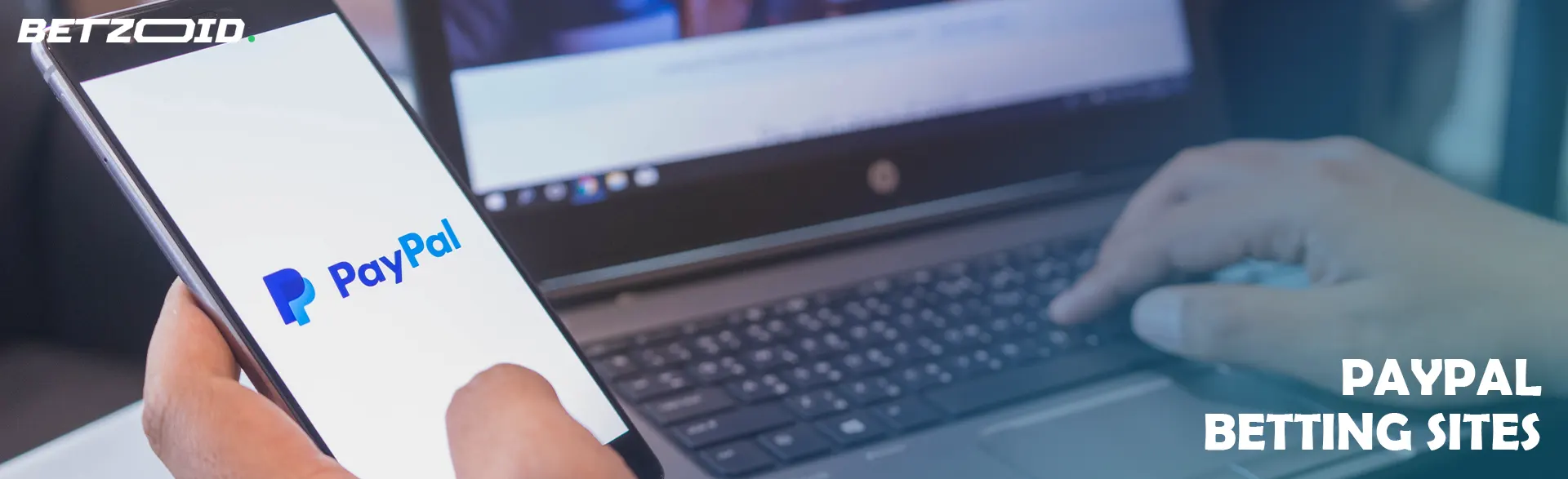 PayPal logo on the screen of a smartphone held by a person.
