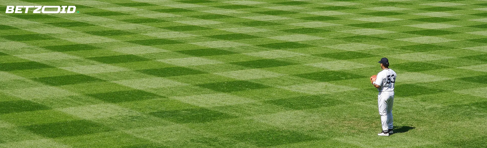 A baseball player stands on an empty field.