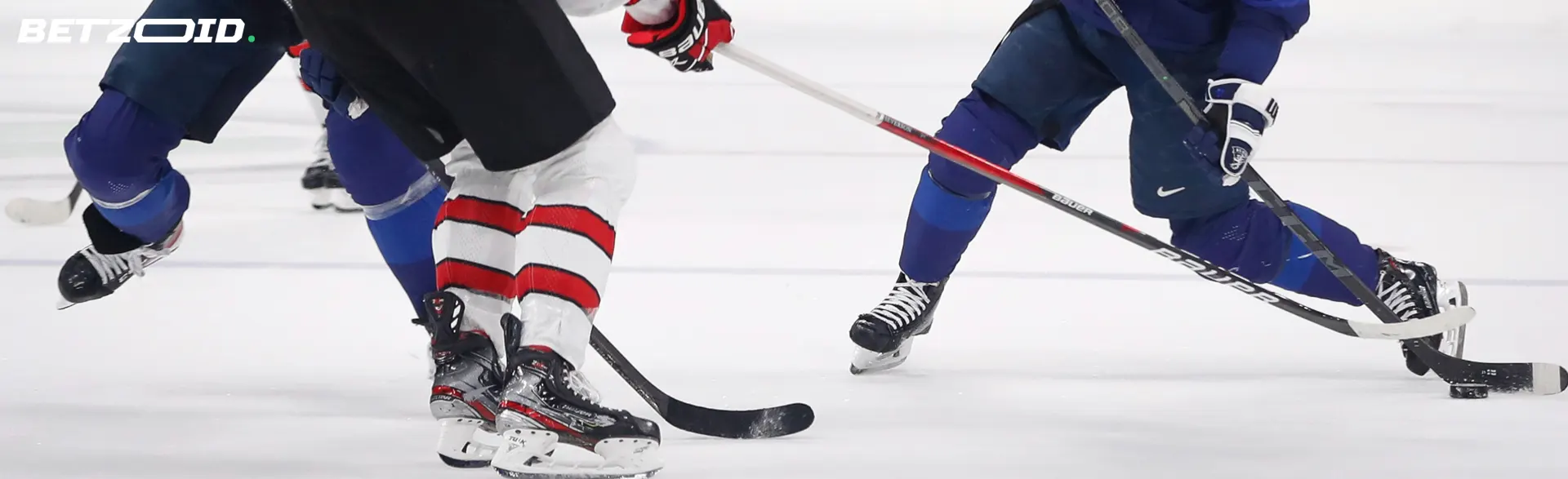 Hockeyspieler kämpfen auf dem Eis um den Puck.