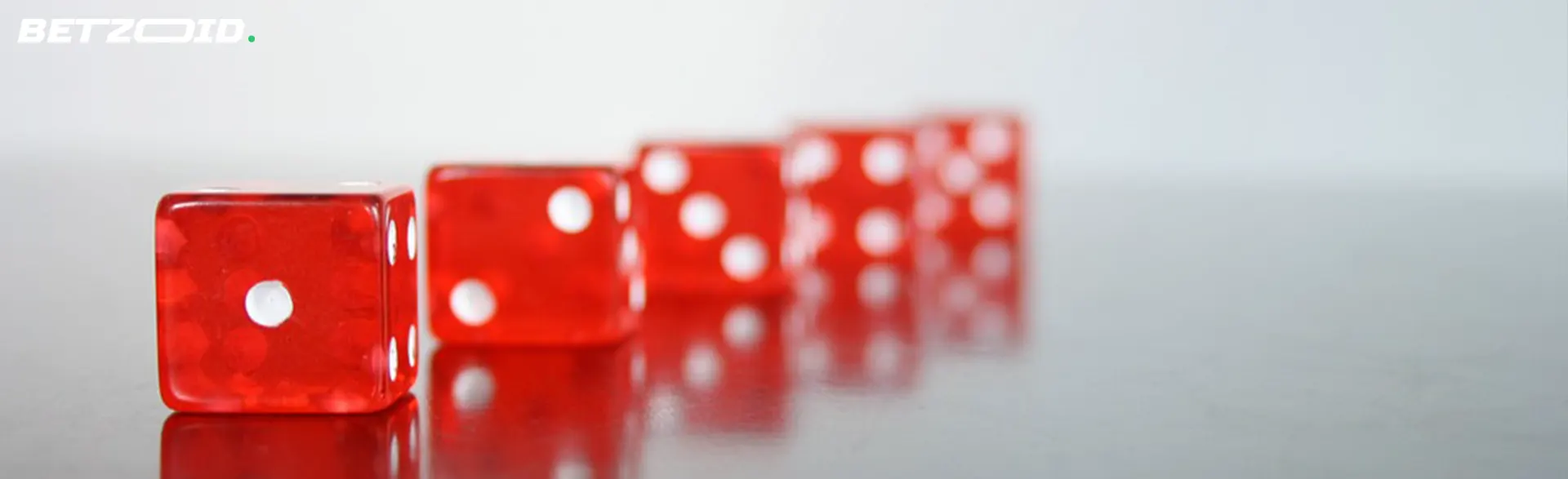 A line of red translucent dice on a reflective surface.