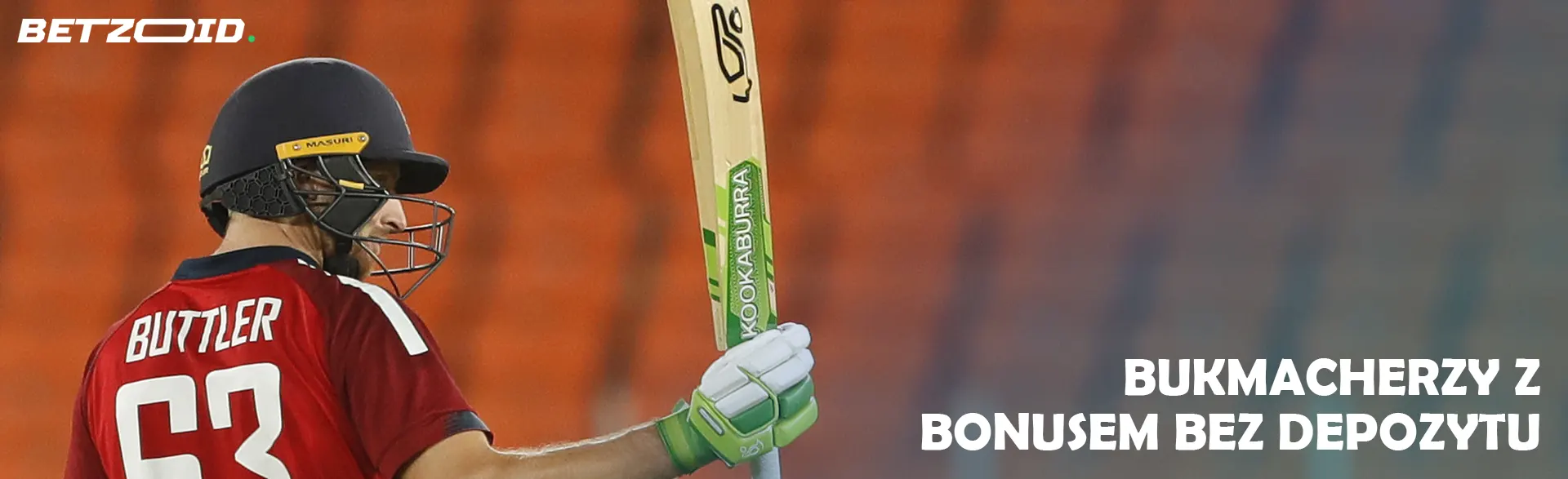 Krykiecista z kijem na tle trybun.