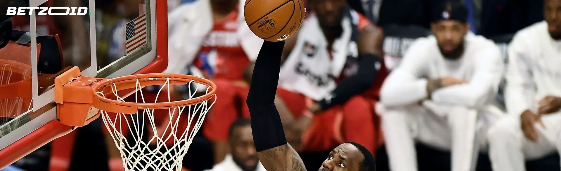 A basketball player tries to throw the ball into the hoop.