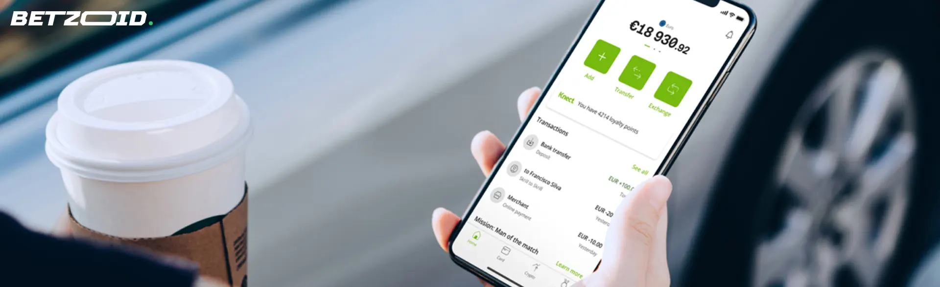 A person holds a smartphone with a balance in the Neteller app.