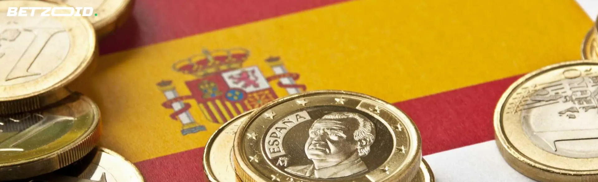 Monedas de euro sobre la bandera de España en casas de apuestas políticas.