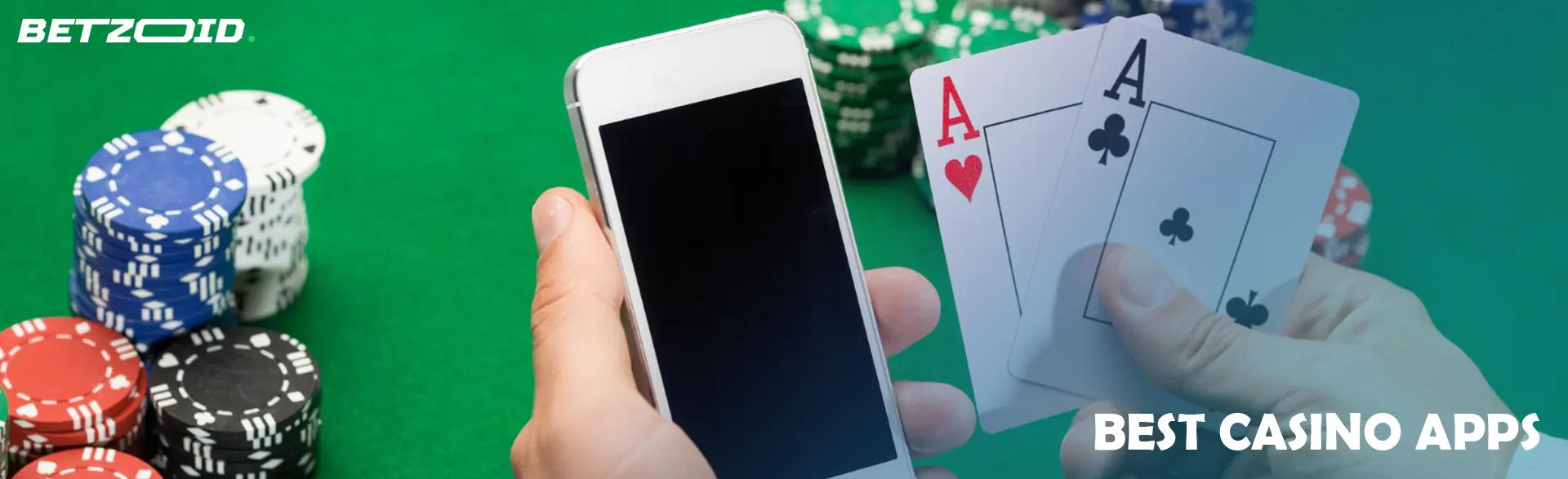 A smartphone and cards in the hands of a player on the background of casino chips.