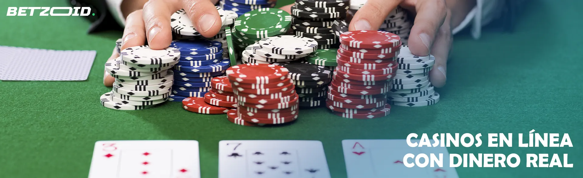 Las manos apilan fichas en una mesa de póquer con cartas.