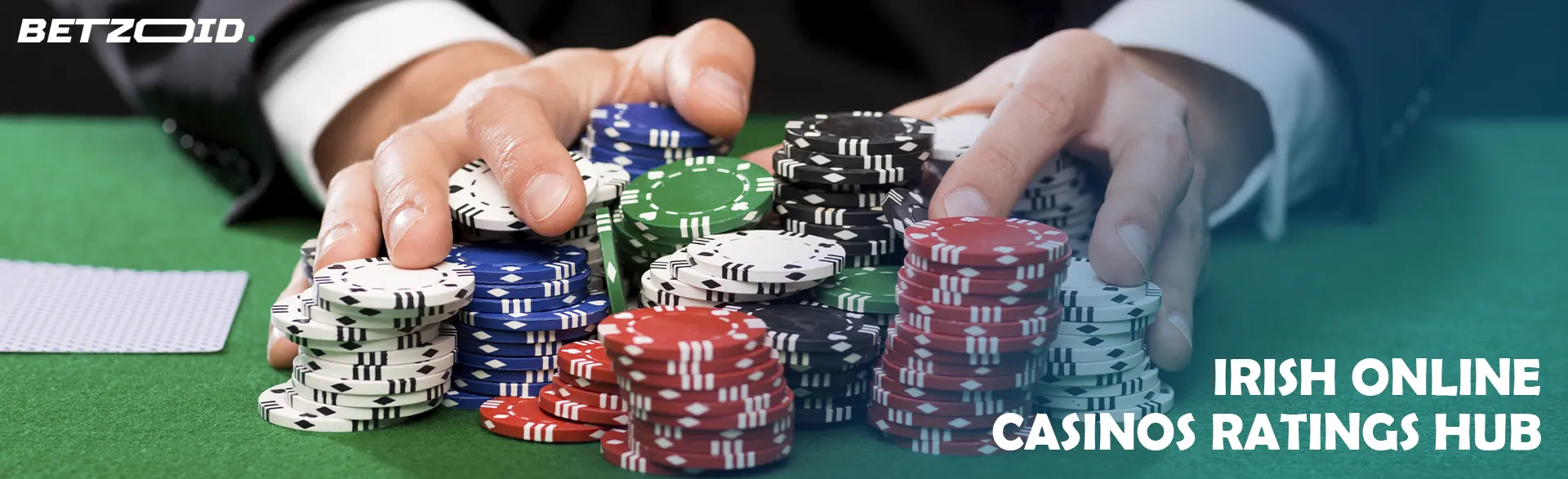 A player holds a pile of chips on a casino table.