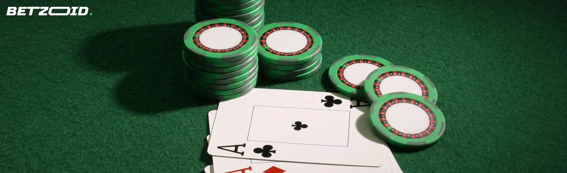 Fichas de casino verdes y naipes sobre la mesa.