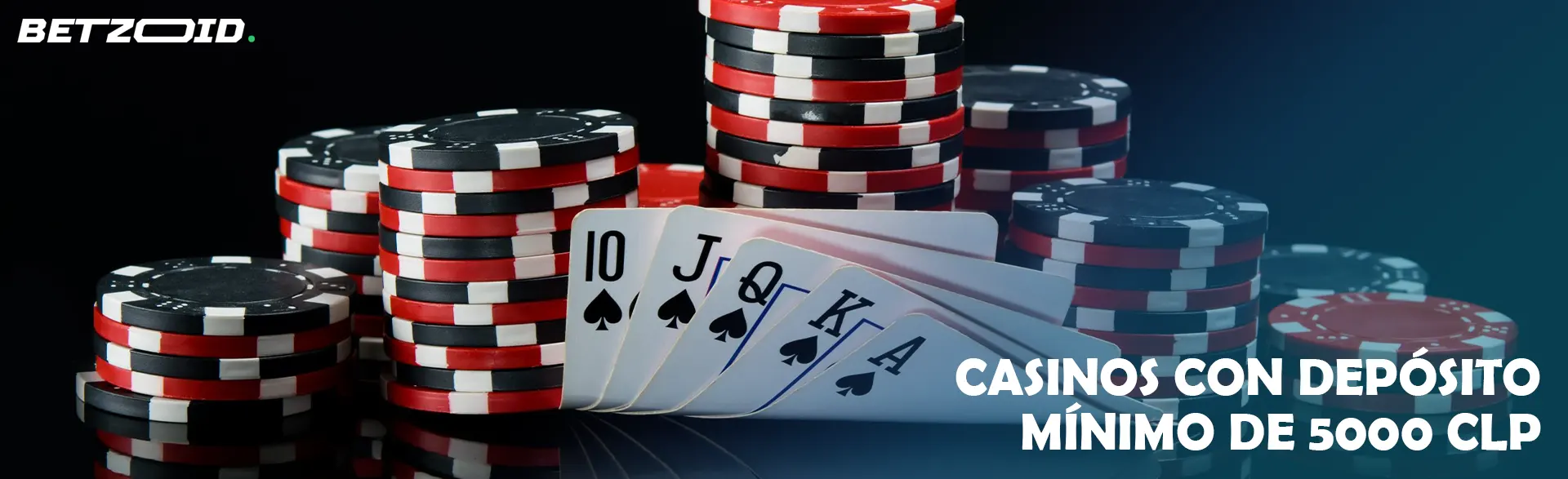 Fichas de casino y cartas sobre un fondo oscuro.