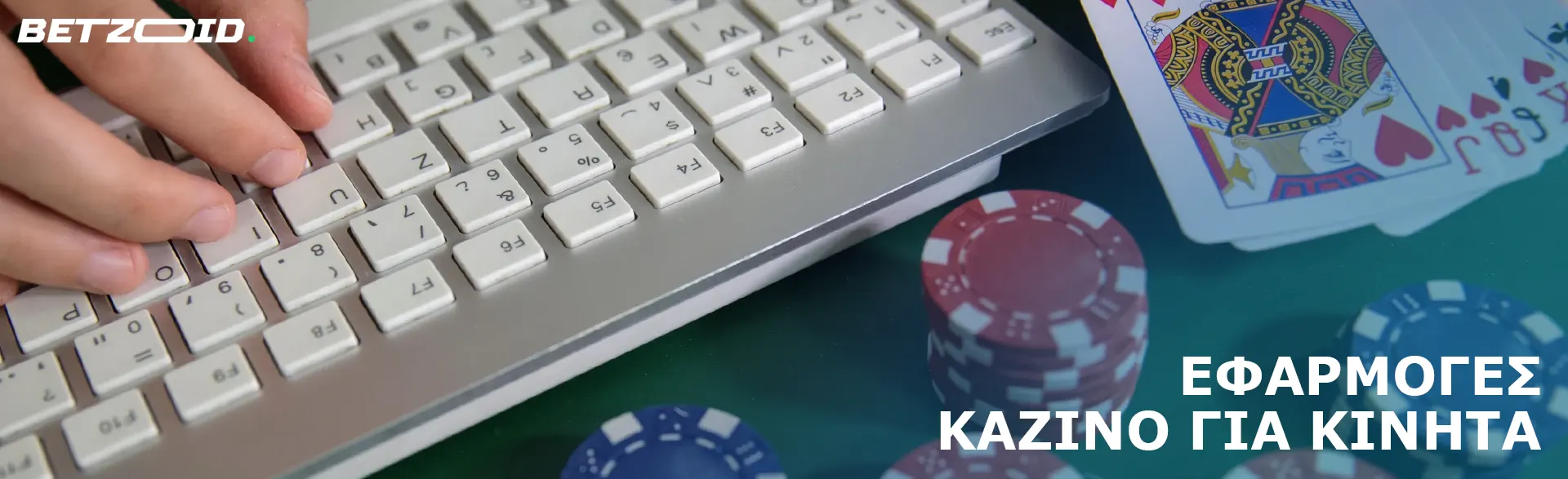 Κάρτες και μάρκες καζίνο δίπλα στο πληκτρολόγιο.