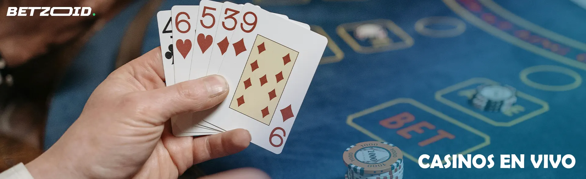 Un jugador sostiene cartas en un juego de casino.