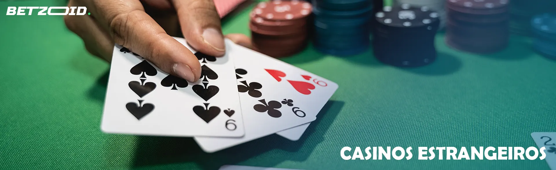 Cartas na mão do jogador junto das fichas do casino.