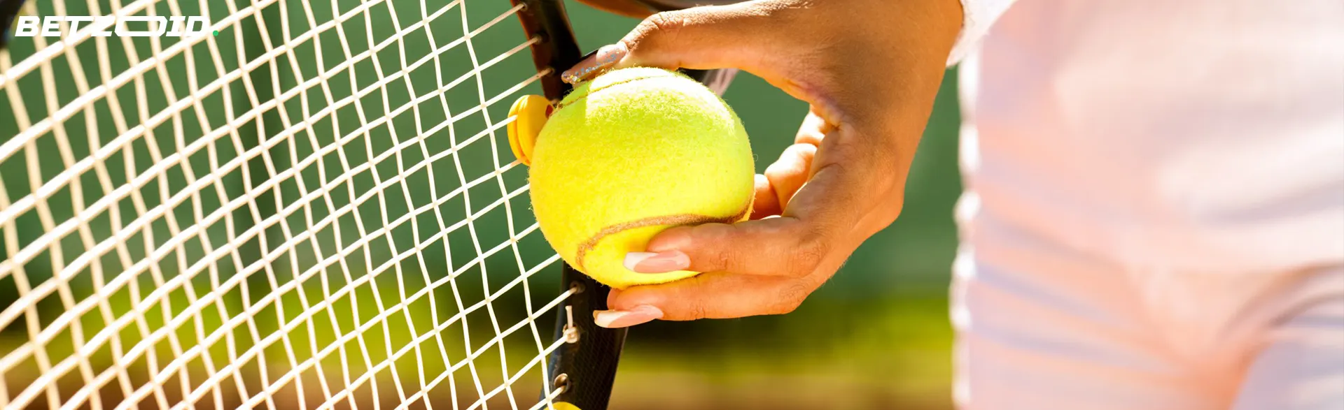 A tennis player applies the ball to the racket.
