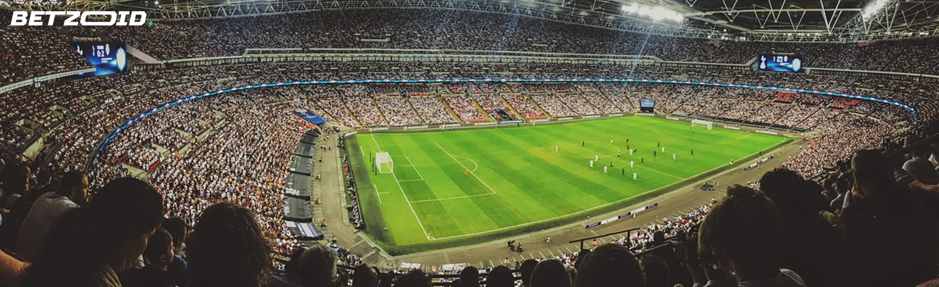Aerial view of a crowded football stadium during a match at night.