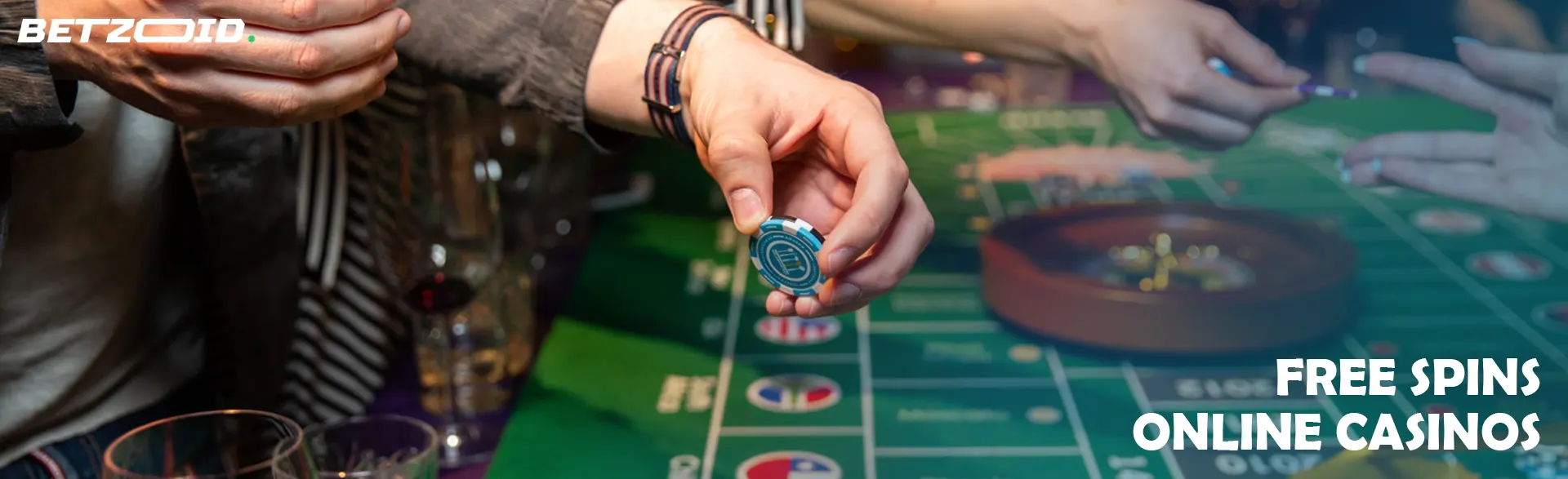 A player holds chips over a roulette table.