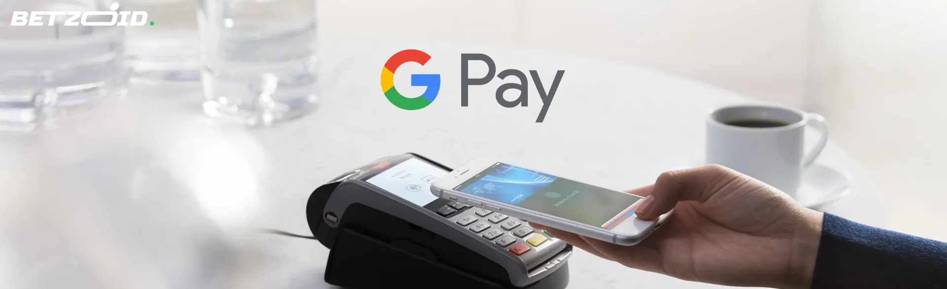 A person makes a payment with a smartphone against the background of the Google Pay logo.