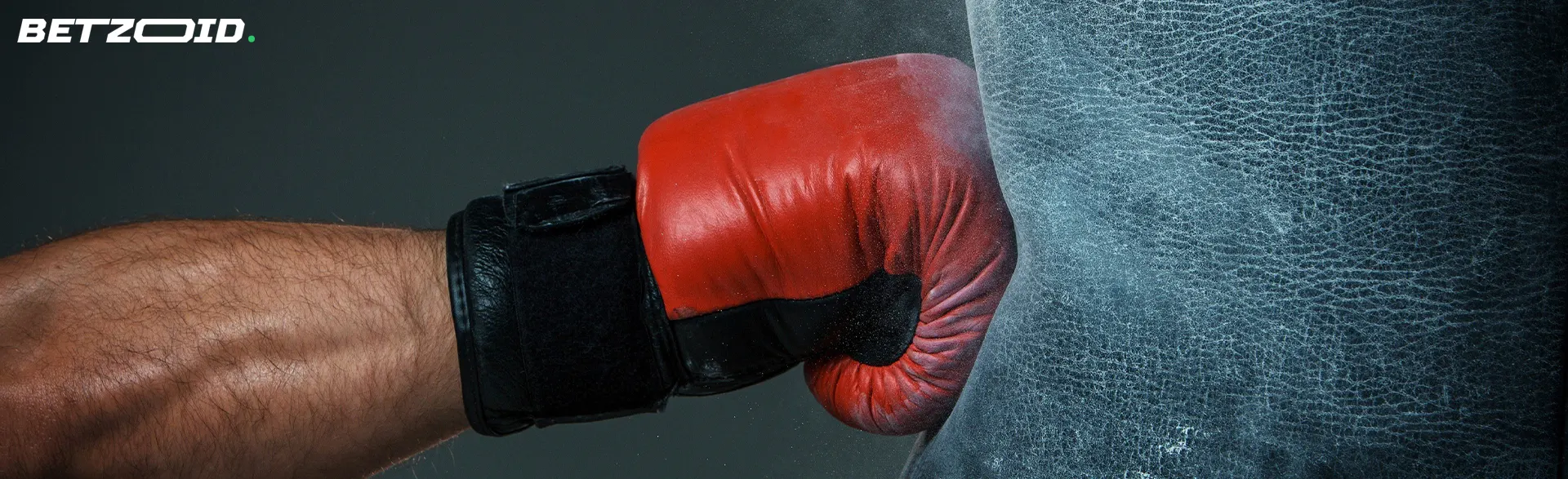 A boxer's hand hits a punching bag.