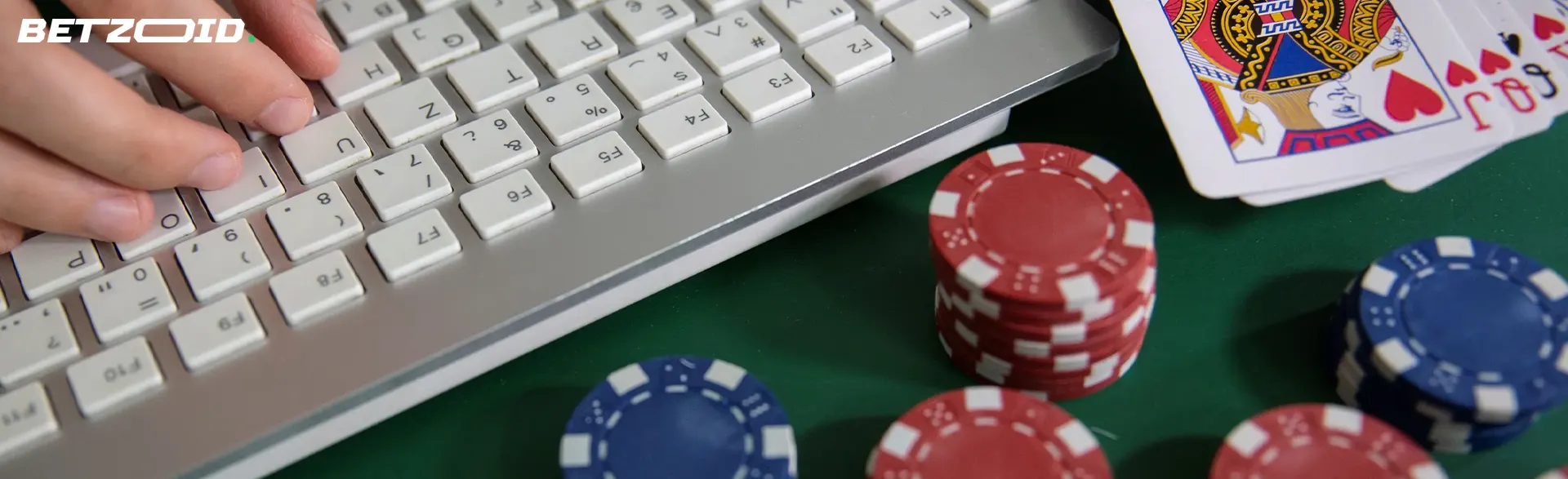 Kasinokortit ja pelimerkit kannettavan tietokoneen näppäimistön vieressä.