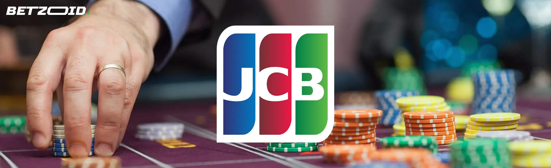 カジノ テーブルにチップを置くプレーヤーの背景に JCB のロゴ。