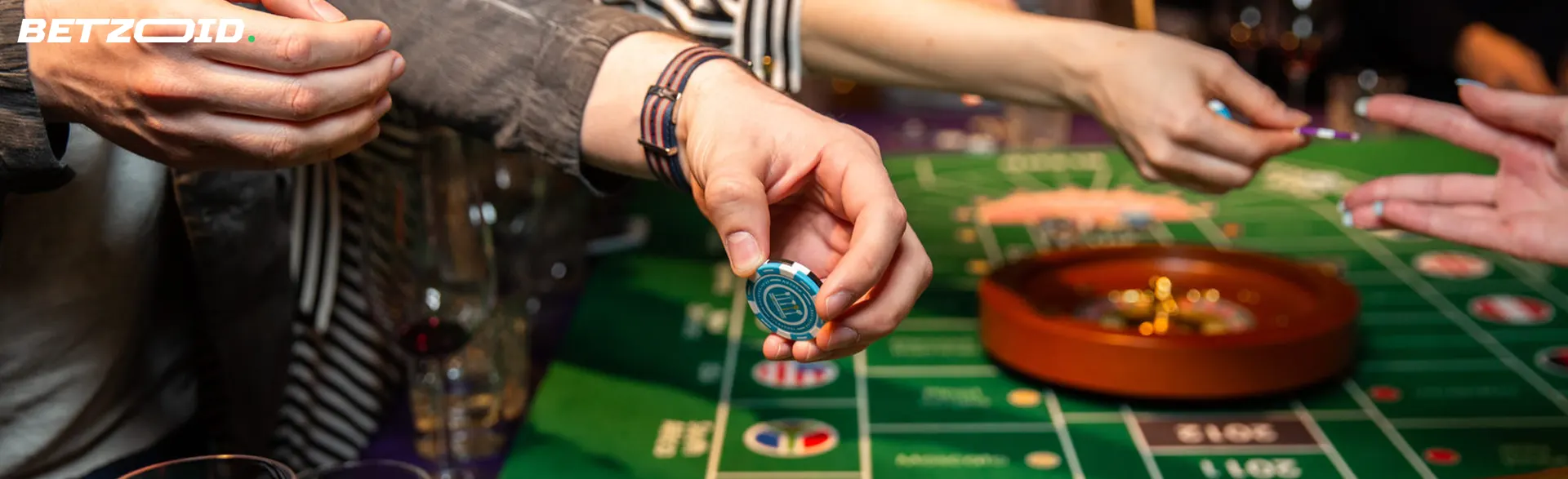 The player holds the chips above the roulette table.