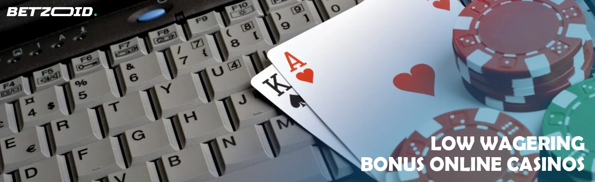 Playing cards and casino chips on a laptop keyboard.