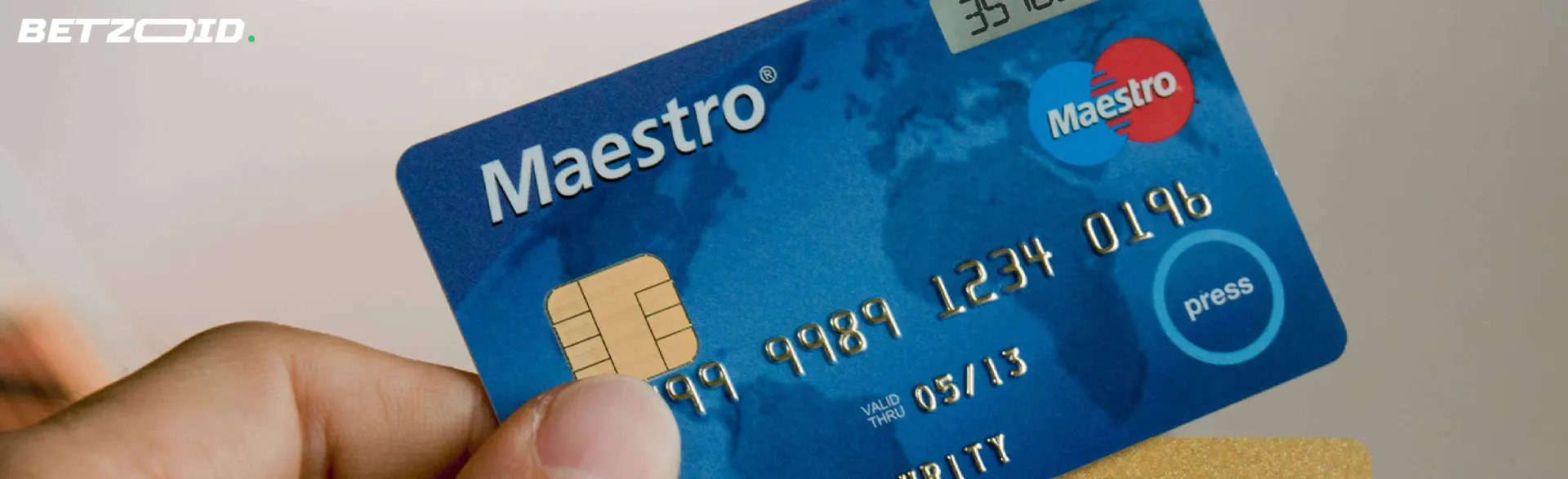 Carta bancaria Maestro in mano.