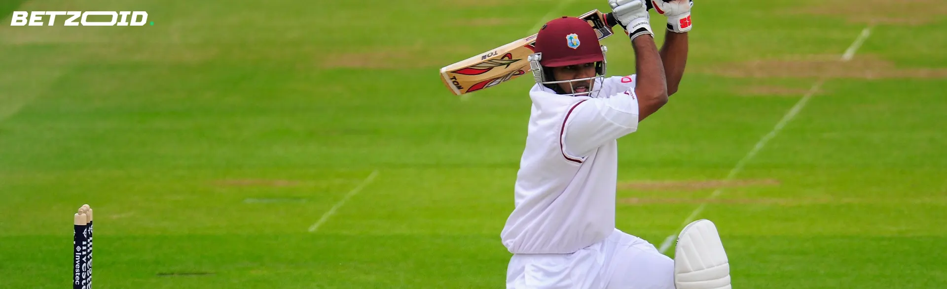 Giocatore di cricket con mazza alzata.