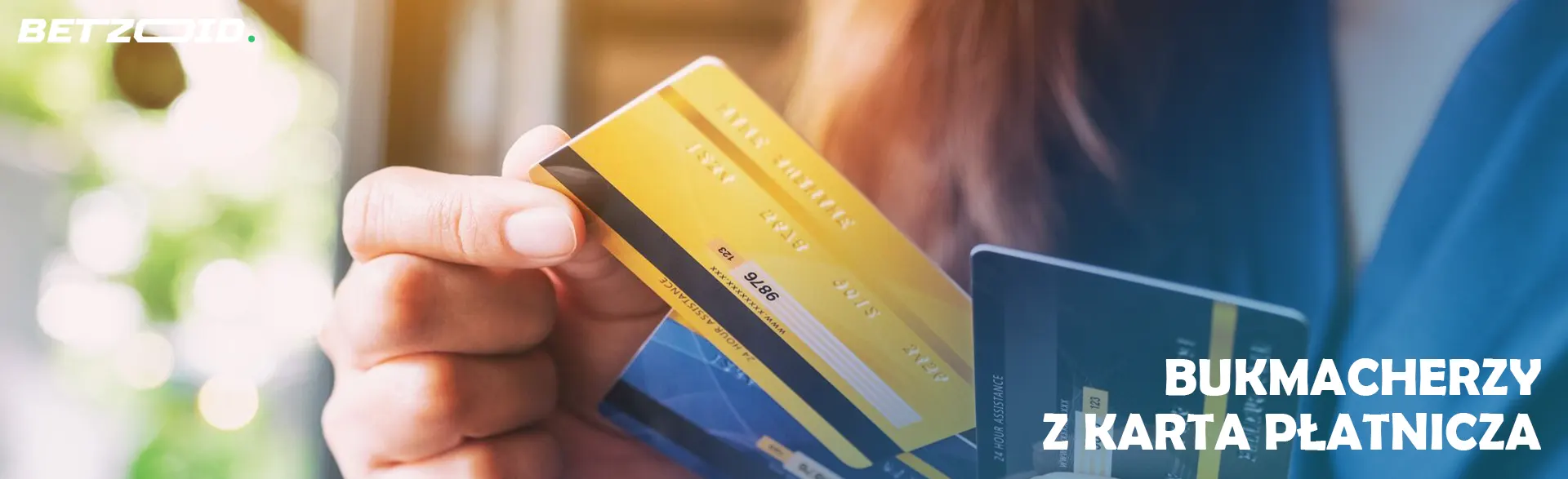 Mężczyzna trzyma w rękach karty bankowe.