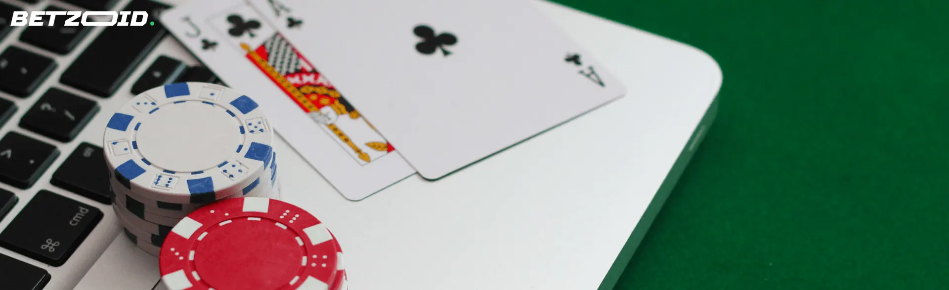 Kasinokortit ja pelimerkit ovat kannettavalla tietokoneella.