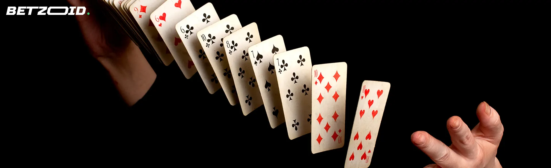 Mies sekoittaa kortteja tummalla taustalla.