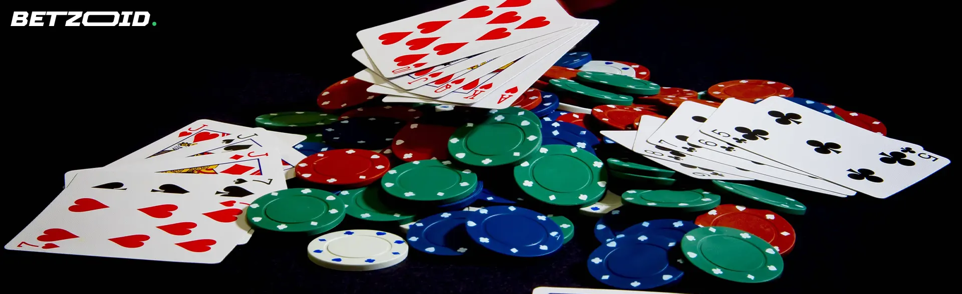 A pile of cards and chips on a dark background.