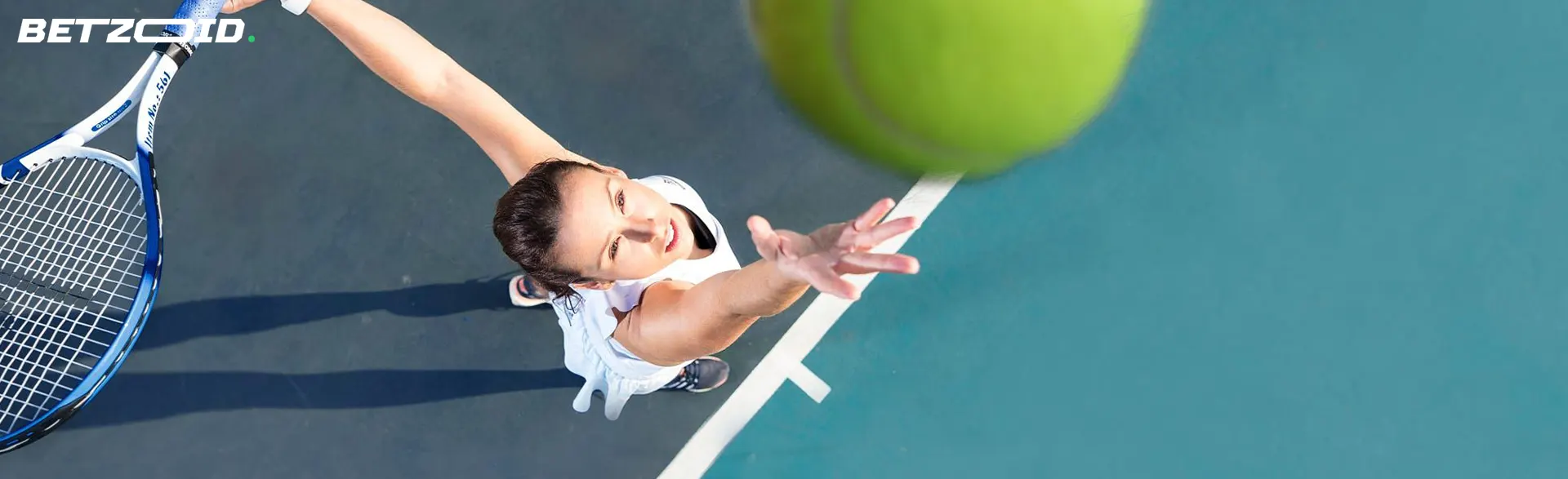 A female tennis player is trying to hit the ball.