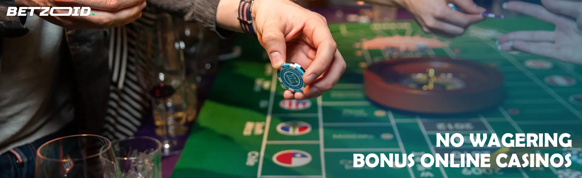 A player holds chips above a roulette table.