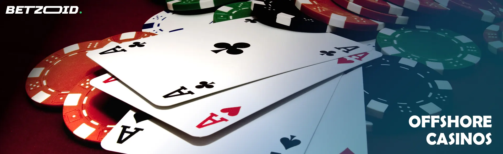 A pile of casino chips and cards on a dark background.